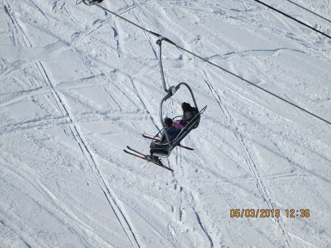 Skiers riding a surface lift on a snow slope at Gulmarg